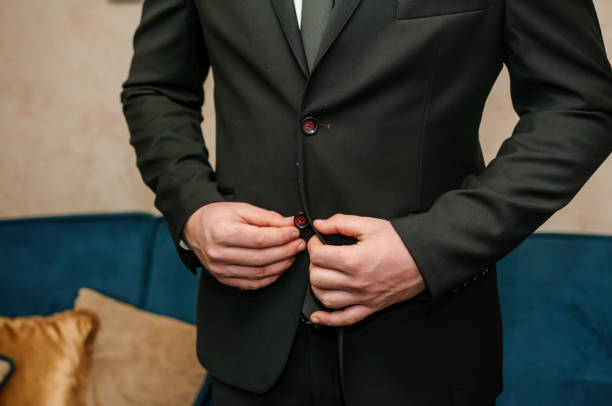 istock The man fasten a button on his jacket. The groom fasten a button on his jacket 1312696518