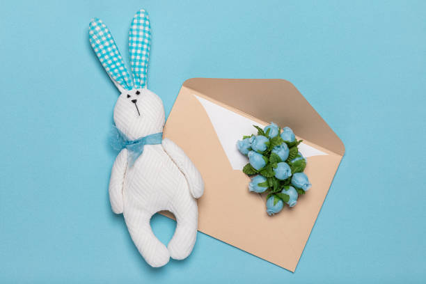 istock Toy white rabbit hare handmade and paper envelope with delicate flowers flat lay. Concept of spring and romance of letters and cards for holidays. 1312696609
