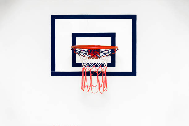 istock Backboard with red metal basketball hoop hangs on white concrete wall 1312702588