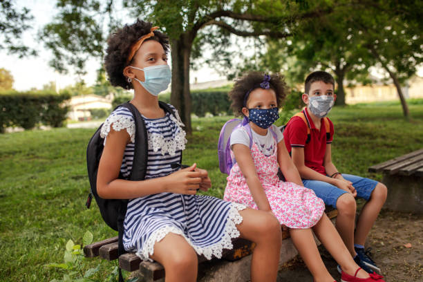 istock Pupils with protective masks sit in the school yard 1312702726