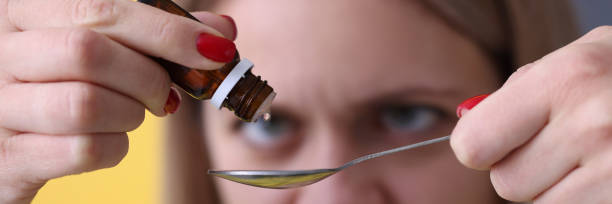 istock Woman dripping drops from medicine bottle closeup 1312704586