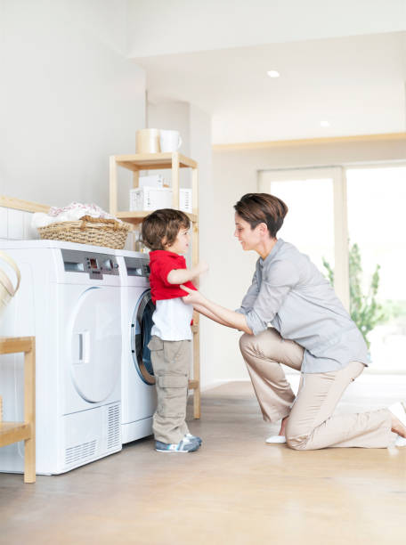 istock Mother and son with clean laundry next to dryer 1312706540