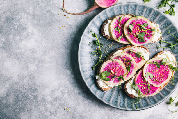 istock Watermelon radish toast with cream cheese and micro-green peas. 1312708742