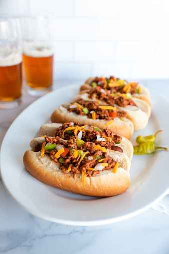 Close up of a plate of chili dogs with glasses of beer in background. in Kingston, ON, Canada