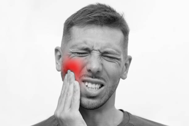 istock Man face with strong tooth pain with red highlighted area. Man suffering from toothache. Teeth problem 1312713998
