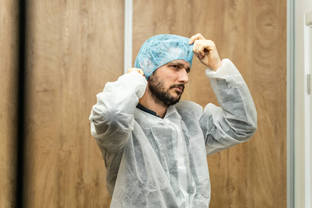 porträt von kaukasischen mann trägt schutzmaske und bouffant mob mütze - junge männliche arzt oder wissenschaftler immer bereit für die arbeit in der labor-krankenhaus frontansicht kopie raum - hair net stock-fotos und bilder