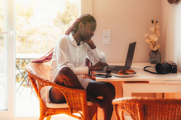 Black girl using a laptop, breakfast