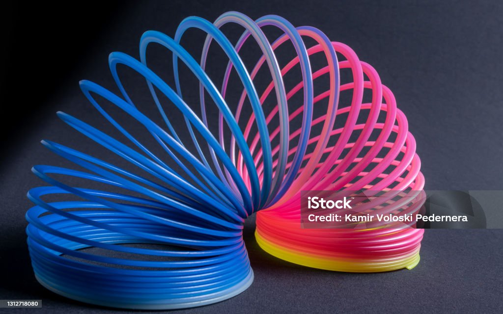 Crazy spring, toy from the 80's and 90's horizontally aligned on a table in yellow, pink and blue colors. Used by many children mainly in Brazil for healthy fun sharing good times with friends. Flexibility Stock Photo
