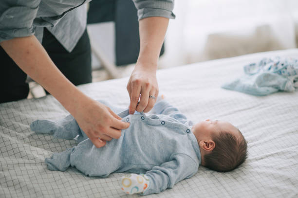 아시아 의 젊은 아버지 퍼 에 버튼 용 그의 아기 소년 에 침대 - changing diaper 뉴스 사진 이미지