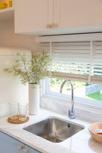 istock Clean new sink in stylish kitchen interior by the window. 1312724805