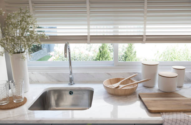 istock Clean new sink in stylish kitchen interior by the window. 1312724807