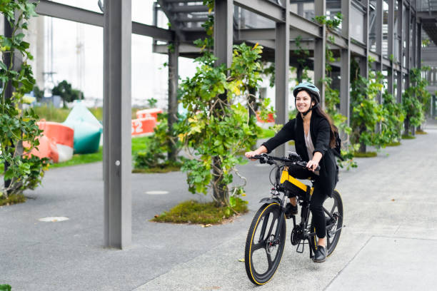 Young woman going to work on electric bicycle. stock photo