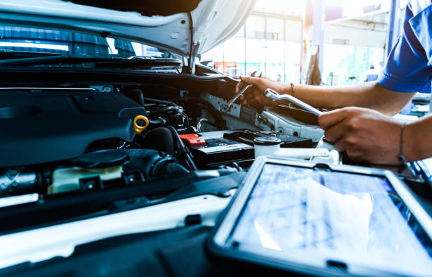 Auto mechanic are checking the condition of the car according to the month. The technician uses the tablet to check. Auto mechanic are checking the condition of the car according to the month. The technician uses the tablet to check. auto repair shop stock pictures, royalty-free photos & images