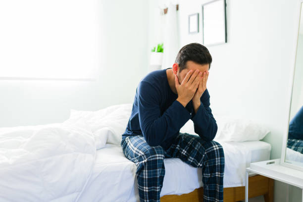 triste uomo latino che si sente stressato dopo essersi svegliato - hangover men crying bed foto e immagini stock