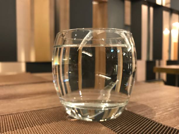 A glass of water on wooden table in a restaurant and ready to drink