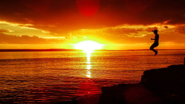 istock Man jumping into a lake at golden sunset. Summer holidays 1312742996