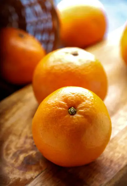 Orange Kinoo Fruit, Indoor Shot With Wooden Basket & Wooden Board