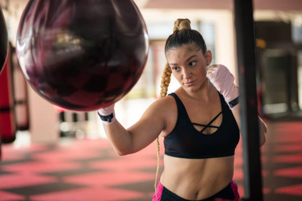 istock Woman boxer punching bag. 1312744234