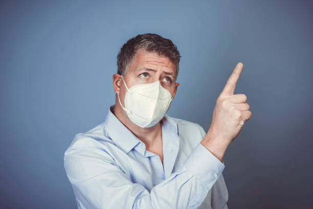istock Middle-aged man with ffp2 protective mask and blue shirt 1312747115