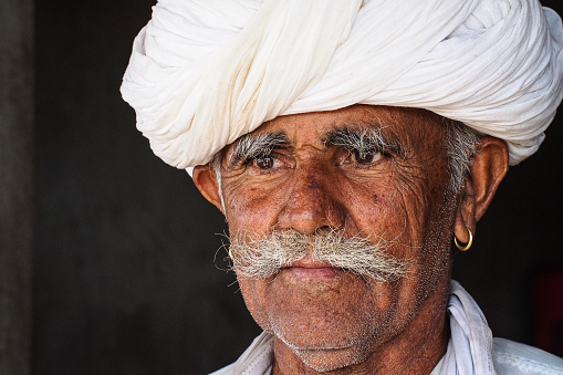 Jodhpur, India - Jan 02, 2020: Portrait of an old man in national white turban headdress in Jodhpur, India