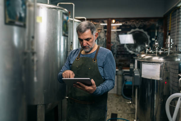 istock worker examine beer in mini craft brewery 1312748295