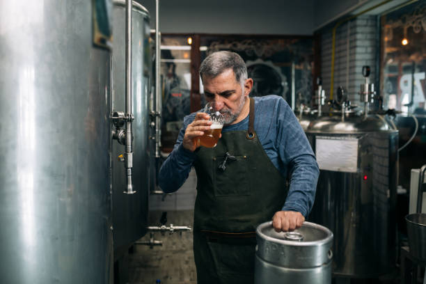 istock worker examine beer in mini craft brewery 1312748429