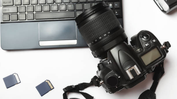 istock Digital camera and laptop. workplace photographer concept. white background 1312749046