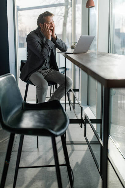istock Happy businessman reading a surprising e-mail on laptop. 1312750322