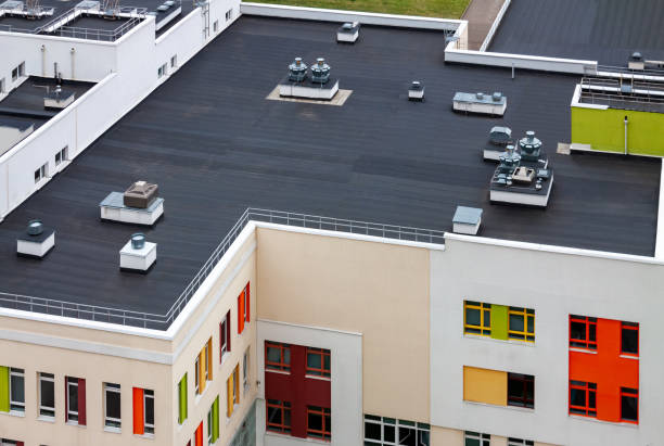 Top view dark flat roof with air conditioners and hydro insulation membranes modern apartment building residential area. Top view flat roof with air conditioners and hydro insulation membranes on top of a modern apartment yellow green red building. industry stock pictures, royalty-free photos & images