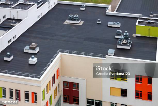 Top View Dark Flat Roof With Air Conditioners And Hydro Insulation Membranes Modern Apartment Building Residential Area Stock Photo - Download Image Now