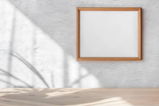istock Horizontal white frame mockup hanging white gray concrete wall background. Scandinavian interior. Selective focus. 1312753368
