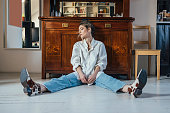 New Normal Concept: Young Beautiful Caucasian Woman Sitting on the White Floor, Looking Down while Thinking about Pre-COVID Era (Horizontal)