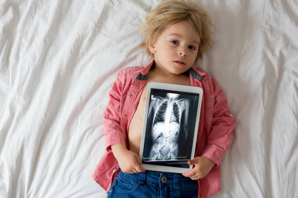 kleinkind kind, halten röntgenbild auf tablette des kinderkörpers mit verschluckten magnet zeigen, kind schlucken gefährliche sittgut - vertebral body stock-fotos und bilder