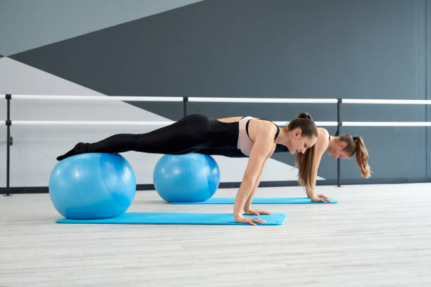istock Women practicing plank position using fitness balls. 1312756434
