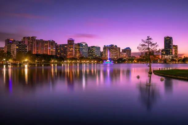 Colorful sunset above Lake Eola and city skyline viewed from the Eola Park in Orlando, Florida. Long exposure.