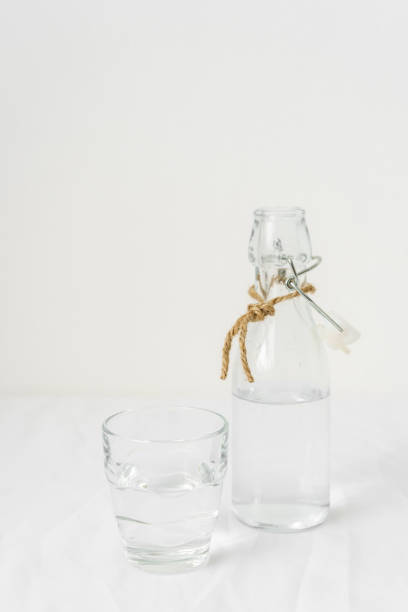 istock A drinking glass and a water bottle on a white tablecloth. 1312758014