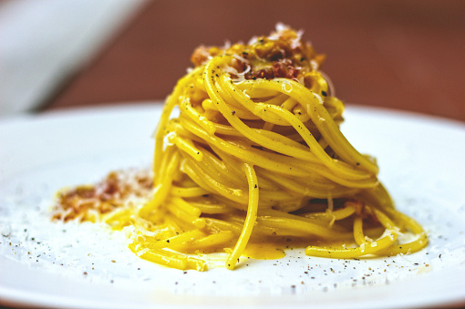 INGREDIENTS:\n\n- 600g of spaghetti\n- 250g guanciale\n- 6 eggs\n- 100g pecorino cheese\n- Salt\n- Black pepper\n\nRECIPE:\n\nPut the water in a pot and bring it to a boil, then add salt to taste.\nCut the guanciale into strips. Some might say that it is better to cut it into cubes, but the advantage of cutting it into strips is that it will become more crispy and consistent. Brown it in a pan, after having sprinkled with pepper. No oil is needed, the bacon is already fat on its own.\nBeat the eggs in a bowl, season with pepper and half the Pecorino cheese (about 50 g), then mix carefully until the mixture is homogeneous and creamy. Remember to add a little bit of the fat of the guanciale during the mixing.\nCook the pasta \