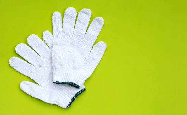 istock White cotton gloves on green background. 1312759587