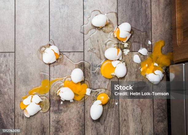 Lot Of Broken Eggs On Brown Home Floor Misfortune Concept Stock Photo - Download Image Now