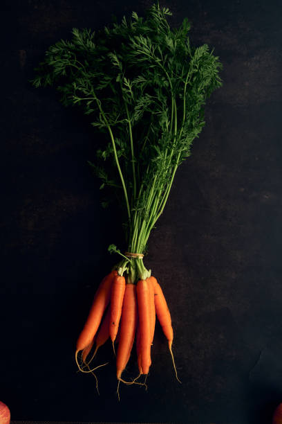 istock clean young carrots on a black background 1312763226