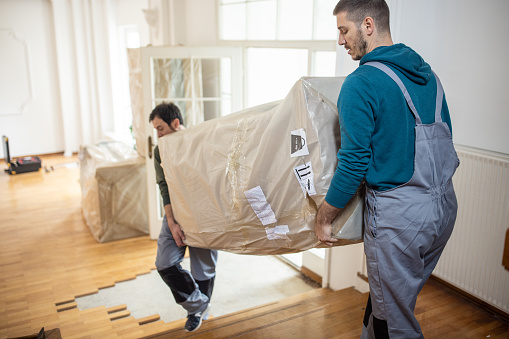 Professional movers bringing in new furniture in house
