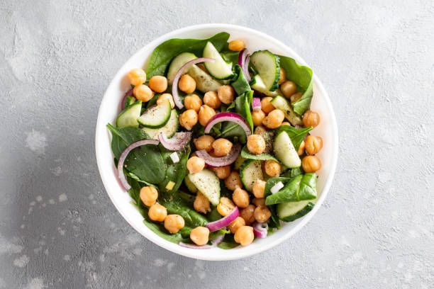 istock Spinach, cucumber, chickpeas, onions and lemon salad on a light table. Top view 1312763742