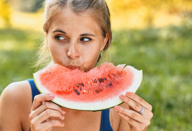 istock Young stylish lady in the park with a watermelon 1312765982