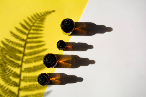 istock Set of bottles for cosmetics on yellow-white background with leaf shadow 1312768681
