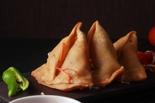 istock Ramadan Special Fried Food Items for Iftar Samosa, Spring roll, kachori with fresh vegetables on table with sauces 1312770155
