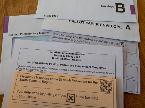 Scottish Parliament Election postal vote papers, for 6 May 2021 election, when 129 members of the Scottish parliament will be elected. It will be the sixth election since 1999 when the Scottish parliament was reestablished. The leader of the winning party will become First Minister and take their position in the Scottish Parliament Building at Holyrood in Edinburgh, Scotland. The householder is being asked to mark their postal ballot paper with a cross to mark their selection for their local MP and wider Scottish leadership. The paperwork needs to be correctly completed and returned in the provided ballot envelopes.