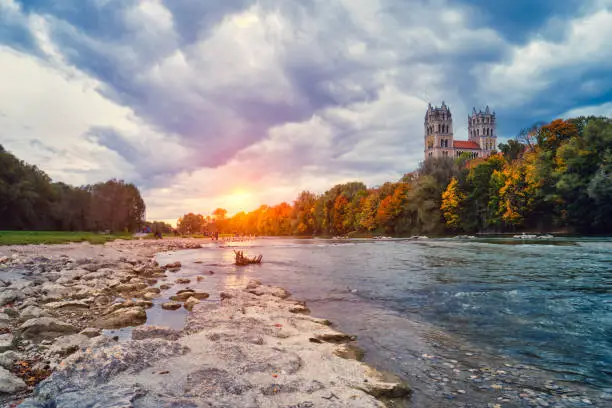 Munich view - Isar river, park and St Maximilian church from Reichenbach Bridge on sunset. Munchen, Bavaria, Germany.