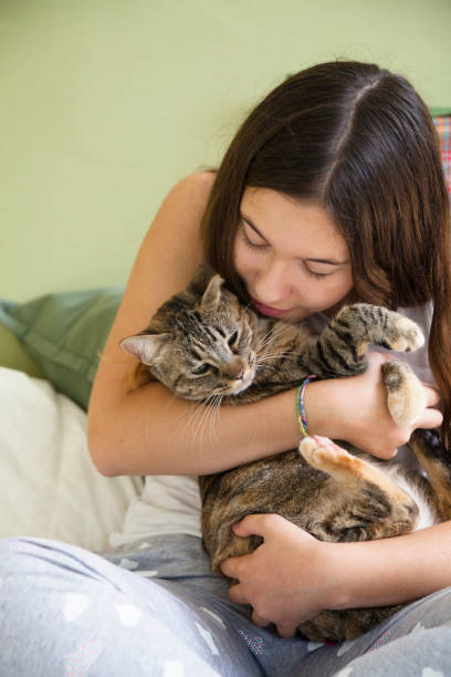 istock Young woman with her cat on a bed 1312772765