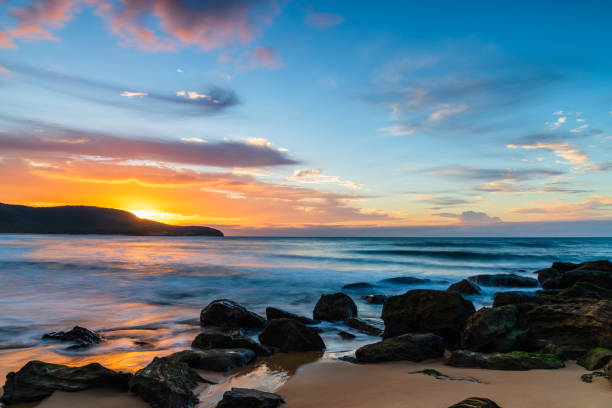 istock Sunrise at the seaside with pastel coloured clouds 1312772909