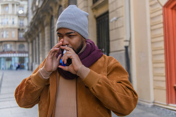 istock Young African-American Man with Protective Face Mask is Having Sinusitis Problems Outside in Nature. 1312776492